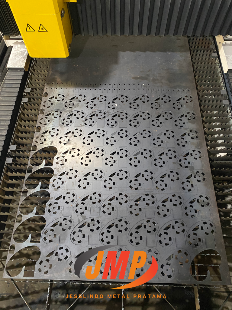 jasa laser cutting Mesin laser cutting CNC sedang memotong lembar logam menjadi komponen presisi di workshop Jesslindo